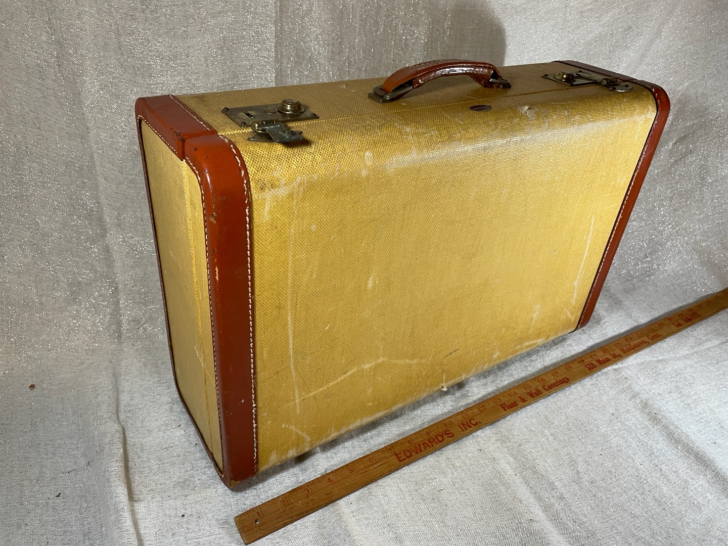 Brown vintage leather suitcase on a wooden deck lying flat viewed